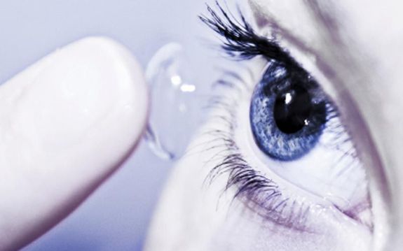 girl with blue eyes putting in contact lense